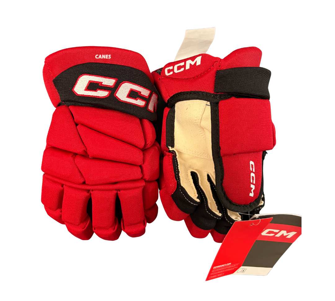 A pair of red and black CCM HGTSC Jr. Canes hockey gloves.
