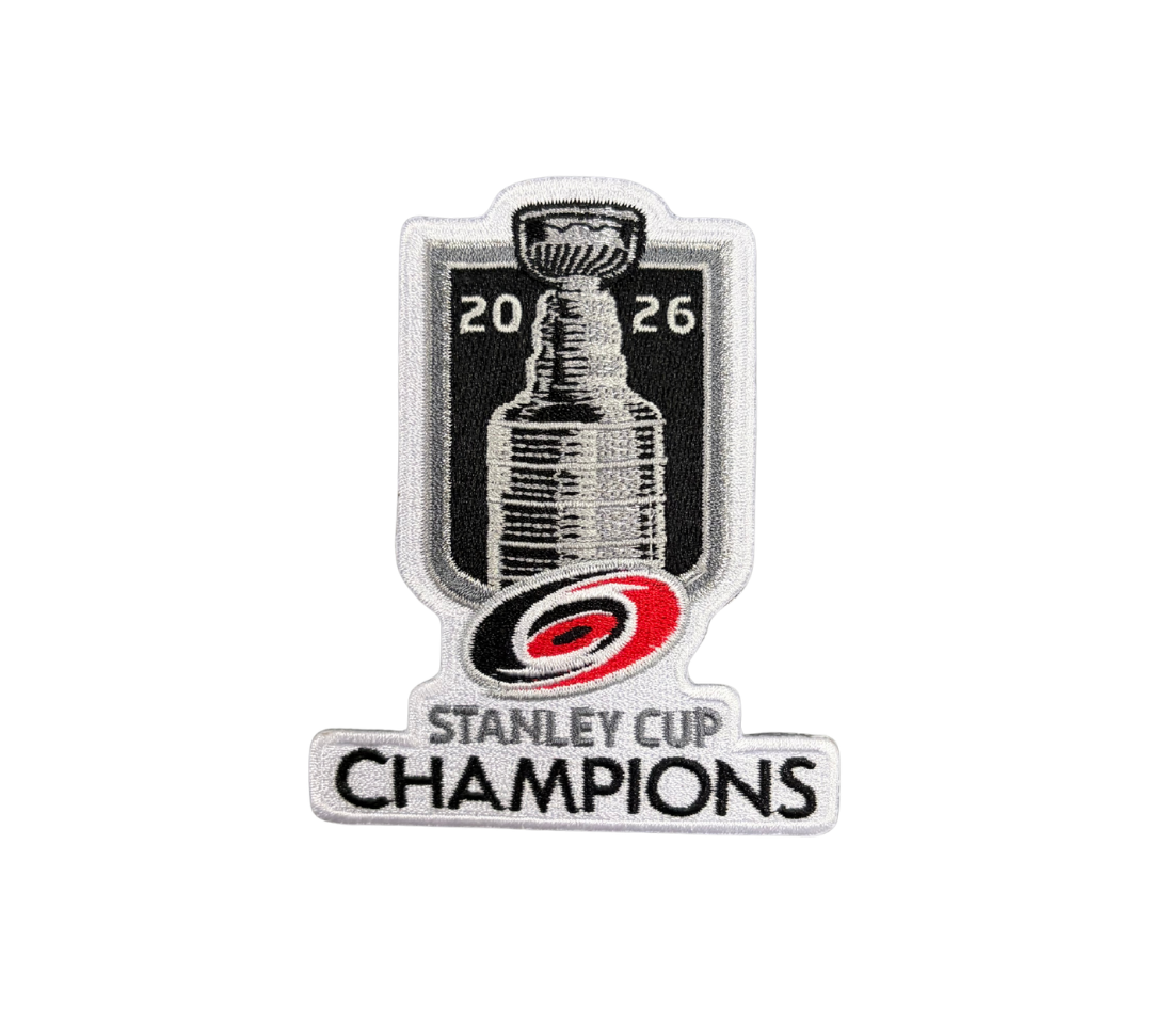 A hockey patch celebrating the 2026 Stanley Cup Champions, featuring a black and white graphic of the Stanley Cup trophy, the Carolina Hurricanes logo in red and black, and the text 'STANLEY CUP CHAMPIONS'.